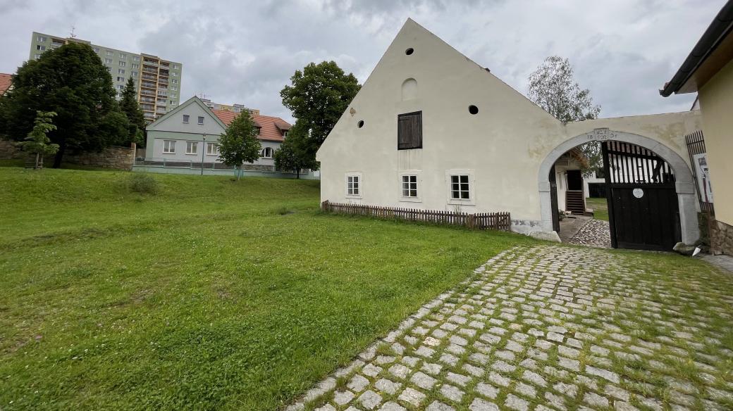 Vyčnívající panelový dům za statkem U Matoušů