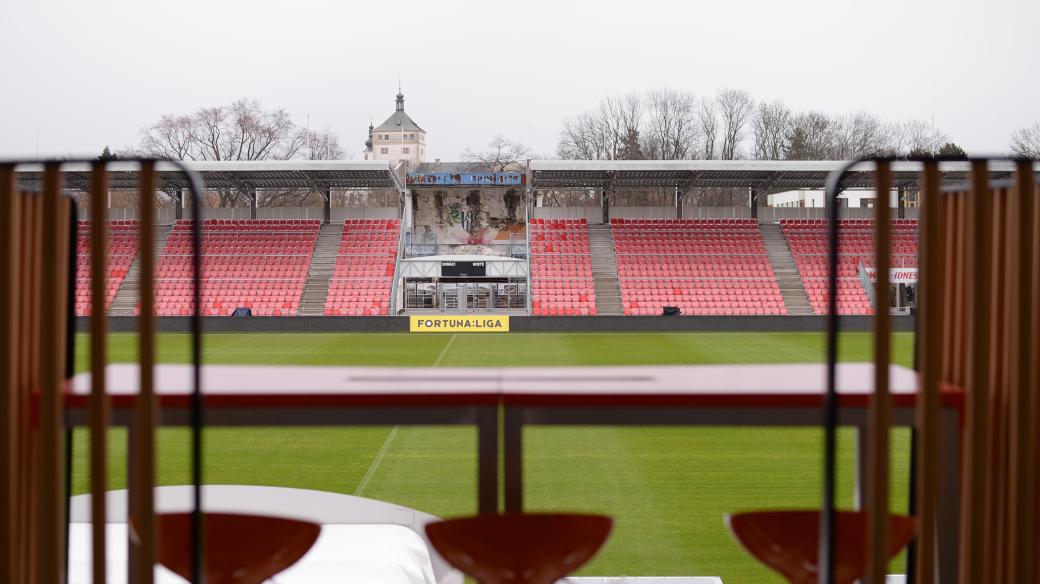 Pohled z hlavní tribuny na trávník pardubického fotbalového stadionu