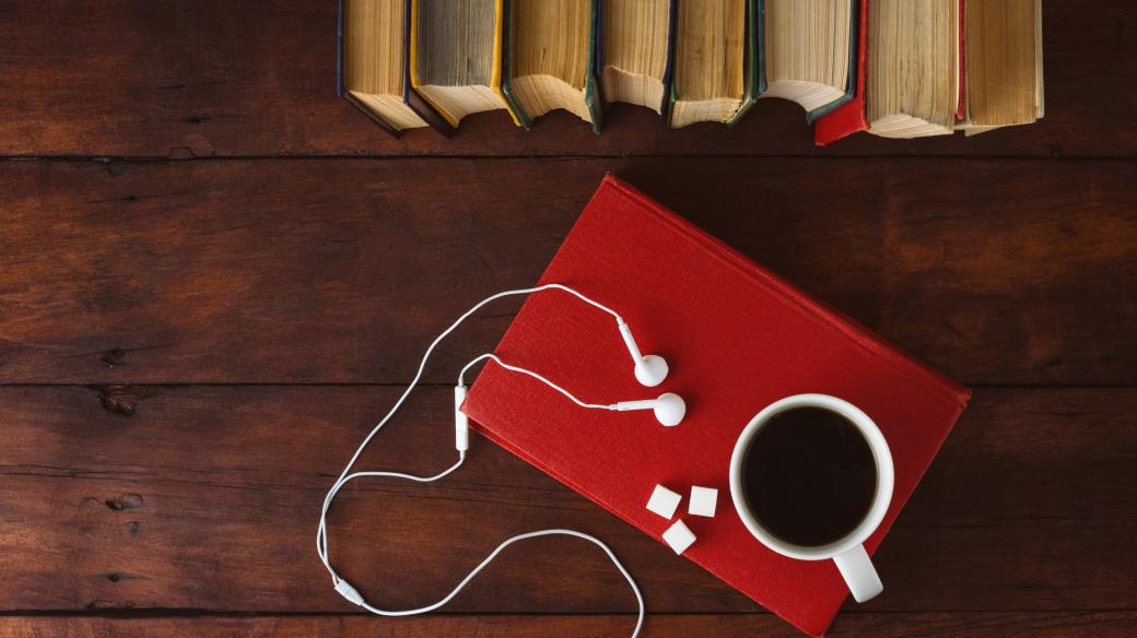 Knihy, bílá sluchátka, kostky cukru, šálek kávy