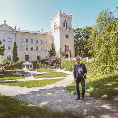 Majitel zámku Chyše Vladimír Lažanský před hlavní fasádou a zámeckým parkem