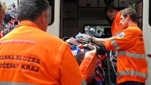 Záchranáři přepravují zraněnou osobu do sanitky
