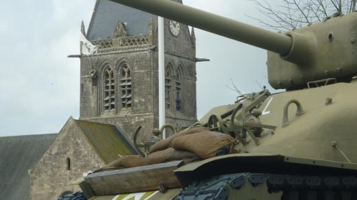 St. Mére Eglise s parašutistou v pozadí 