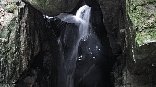 Balvan působí, jako by se pod vodopádem někdo sprchoval