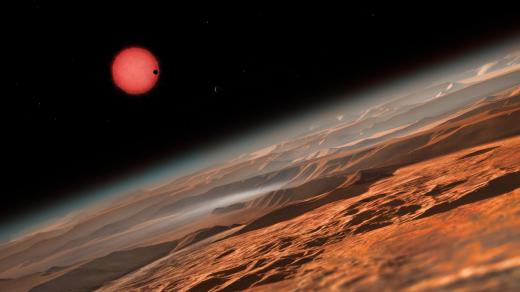 Chladná trpasličí hvězda TRAPPIST-1 při pohledu z oběžné dráhy kolem jedné z jejich planet, v představě výtvarníka