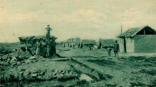 Historická pohlednice s názvem Cikánská vesnice v berežské župě nedaleko Mukačeva, Podkarpatská Rus, kol. roku 1925. (Vydal odbor Klubu československých turistů v Mukačevě ve vydavatelství Karpatia Mukačevo)