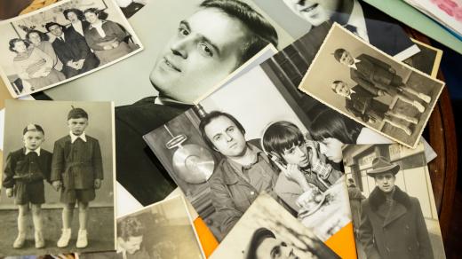 Milena ukazuje fotografie svého otce, zcela vlevo je fotografie Jiřího Gruši z dětství, spolu s jeho bratrem