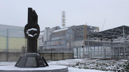 Černobyl je plný pomníků. Tento z roku 2006 nesoucí nápis "Těm, kdo zachránili svět" stojí hned před tzv. starým sarkofágem (budova v pozadí), pod nímž je pohřben havarovaný 4. blok