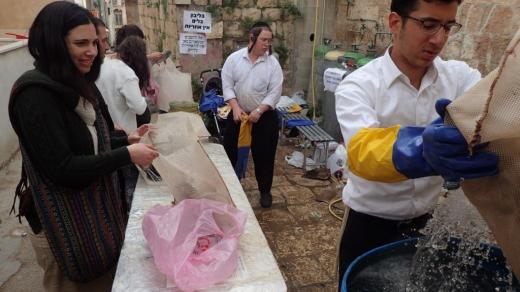 Hospodyňky z okolí snášejí před svátkem pesach vybavení své kuchyně na ulici, aby je nechaly očistit horkou vodou a párou