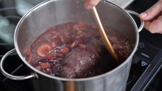 Zatažené maso přidáme do kastrolu se základem, přidáme nakrájenou rebarboru, divoké koření a zalijeme vínem, vývarem a dusíme