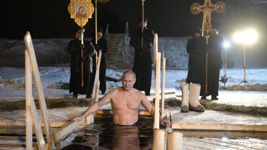 Putin demonstroval před kamerami svou kondici koupelí v díře v ledu vysekané pro něj do hladiny zamrzlého jezera