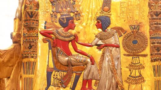 Faraon Tutanchamon ve výjevu na opěrce křesla