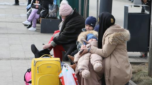 Žena s dětmi na ulici ve Lvově prchající před válkou na Ukrajině