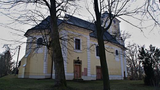 Kostel sv. Petra a Pavla stojí v menším parčíku nad vesnicí i zámkem