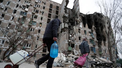Obyvatelé Mariupolu si odnášejí humanitární pomoc.