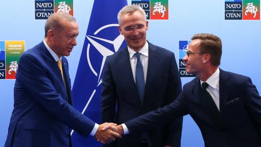 Turecký prezident Tayyip Erdogan a švédský premiér Ulf Kristersson si podávají ruce vedle generálního tajemníka NATO Jense Stoltenberga před jejich setkáním v předvečer summitu NATO ve Vilniusu