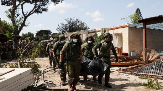 Vojáci odnáší těla obětí v kibucu Kfar Aza, kde podle zpravodajského webu The Times of Israel Hamás v sobotu zavraždil 70 izraelských civilistů.