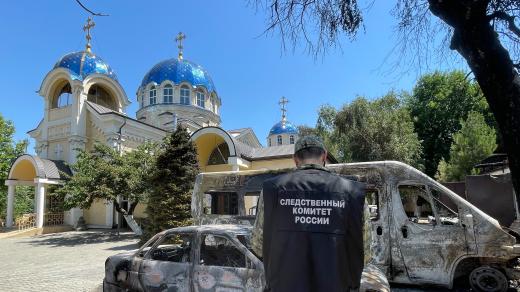 Ruský vyšetřovatel před pravoslavným chrámem poškozeným při teroristickém útoku