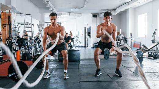Muži cvičí s lany při crossfitovém tréninku