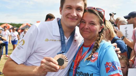 Michal Čupr ukazuje svou medaili z olympiády v Paříži na Olympijském festivalu u jezera Most