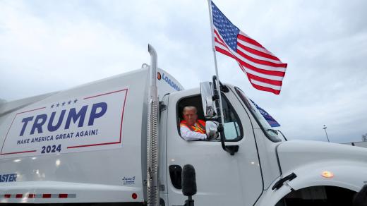 Republikánský kandidát na prezidenta a bývalý americký prezident Donald Trump s reflexní vestou sedí v popelářském voze na letištní ploše mezinárodního letiště Green Bay Austin Straubel v Green Bay ve Wisconsinu, USA