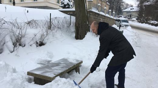 Radim Vácha, předseda spolku Sonow, který dvě sklářské lavičky ve městě opravil, odstraňuje sníh ze sklářské lavičky