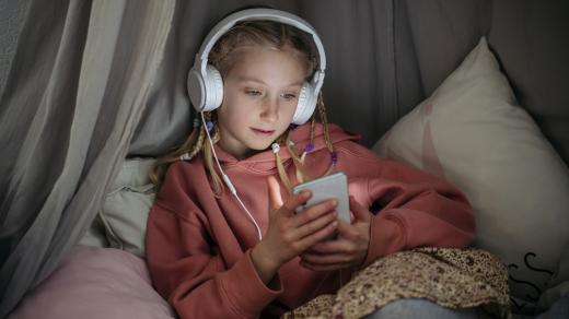 Dívka sleduje sociální sítě na telefonu