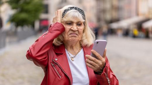 Zoufalá seniorka s mobilním telefonem