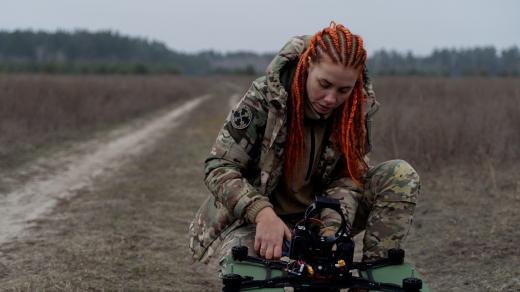 Ukrajinská vojačka připravuje dron, který je ve vzduchu připevněný k optickému vláknu