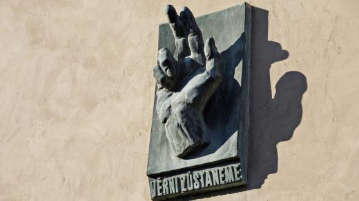 Plastika dlaně s nápisem Věrni zůstaneme na fasádě kostela svatého Mikuláše na Staroměstském náměstí v Praze