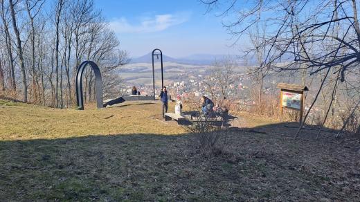 Někdejší předhradí nově ozdobila moderně pojatá brána a zvonička připomínající tragickou událost