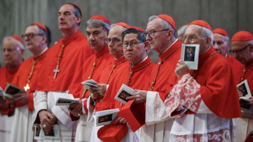 Kardinál Luis Antonio Tagle, kardinál Pietro Parolin a další kardinálové stojí v den předání bohu těla papeže Františka v bazilice svatého Petra ve Vatikánu.