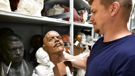 Historik Jan Ivanega prohlíží bustu Vladimira Iljiče Lenina uloženou v depozitáři