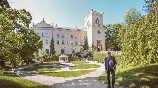 Majitel zámku Chyše Vladimír Lažanský před hlavní fasádou a zámeckým parkem
