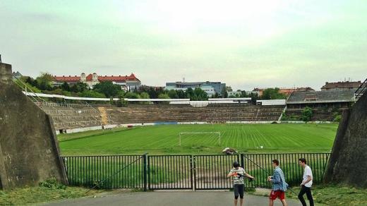 Pohled na brněnský stadion Za Lužánkami. Vymýcená tribuna nalevo, zarostlá napravo