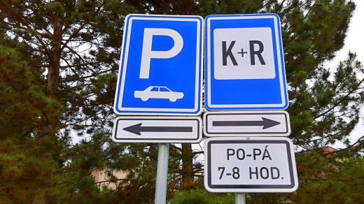 Značka K+R informuje řidiče-rodiče, aby políbili své děti a rychle z parkovacího stání odjeli