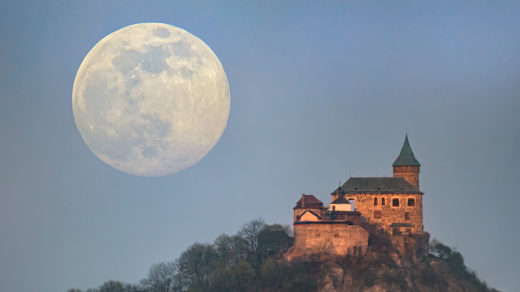 Měsíc v superúplňku vycházející za hradem Kunětická hora na Pardubicku