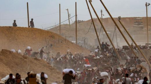 Palestinci v davu odnášejí pomoc od zásilky shozené organizací Gaza Humanitarian Foundation podporované USA (1. srpna 2025)