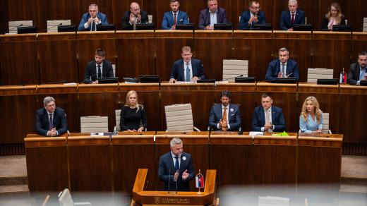 Národní rada Slovenské republiky. V první řadě za řečnickým pultíkem sedí členové vlády, za nimi uprostřed předsedající schůze a vedle něj místopředsedové parlamentu a v horní řadě poté předsedové parlamentních výborů