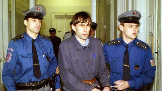 Členové justiční stráže přivádějí dvojnásobného vraha Ladislava Winkelbauera k Okresnímu soudu v Karlových Varech