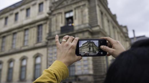 Lidé si fotí rozbité okno, kterým pronikli zloději do muzea Louvre