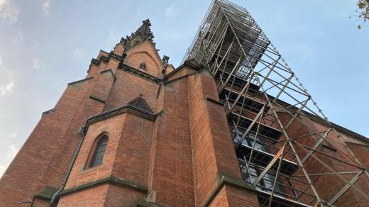 Po straně brněnského Červeného kostela stojí lešení a na střeše pracují pokrývači a klempíři