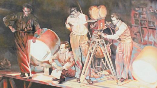 Barrandovské ateliéry. Na jednom z nich je obří kresba znázorňující legendárního režiséra Martina Friče při práci