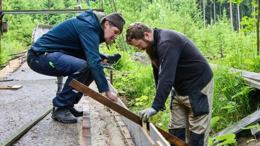 Ondřej Hyman a Petr Kitzberger při opravě sáňkařské dráhy ve Smržovce