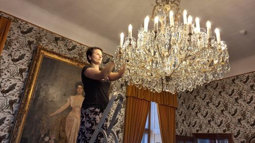 Marika Frantová pečlivě umývá lustr z 19. století