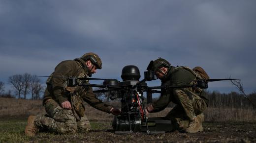 Ukrajinští vojáci připevňují před zkušebním letem na cvičišti v Záporožské oblasti bombu k dronu (fotografie z 23. března 2026)