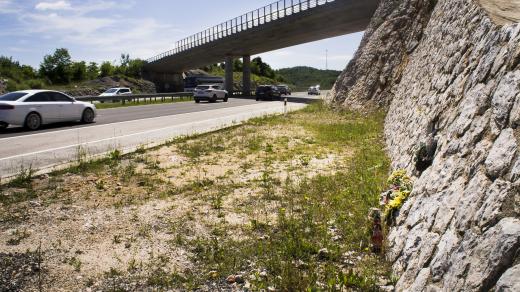 Improvizovaný pomník a květiny (na snímku z června 2014) na místě, kde autobus sjel z chorvatské dálnice A1 u tunelu Krpani, narazil do svodidel a převrátil se
