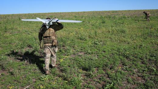 Ukrajinský voják nese průzkumný dron před jeho vypuštěním nedaleko frontové linie (22. května 2026)