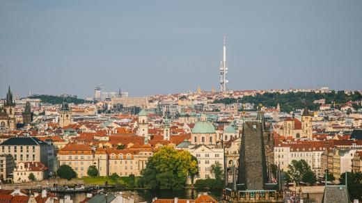 Historické centrum Prahy s Malostranskou mosteckou věží v popředí, dále Staré a Nové Město, v pozadí Žižkov a Vinohrady s Žižkovským televizním vysílačem na horizontu
