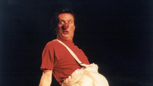 Herec, klaun, autor a režisér Bolek Polívka na jevišti s klaunským nosem jako miminko (2002)