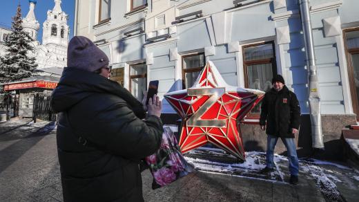 Muž v centru Moskvy vedle instalace rudé hvězdy s písmenem „Z“